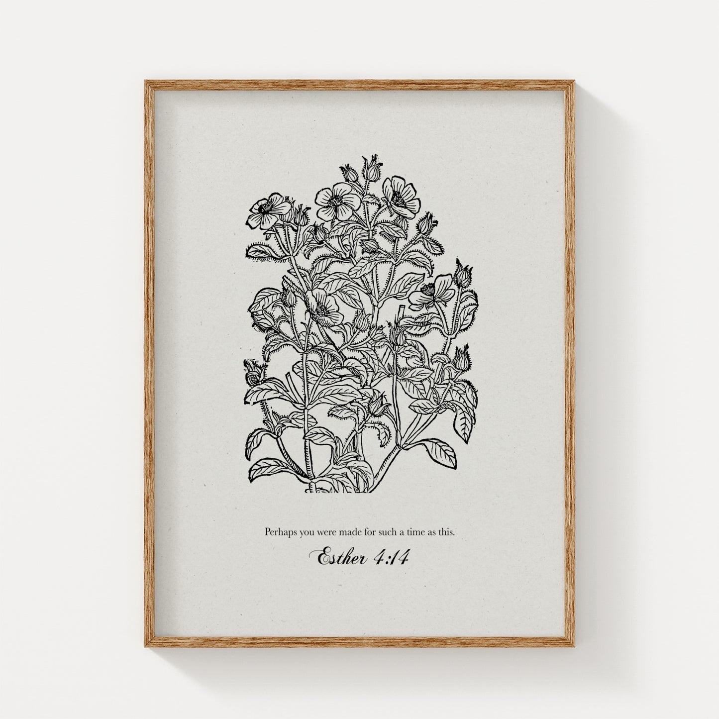 Close-up of the botanical art print featuring black floral illustrations and Esther 4:14, framed in natural wood on a plain white background.