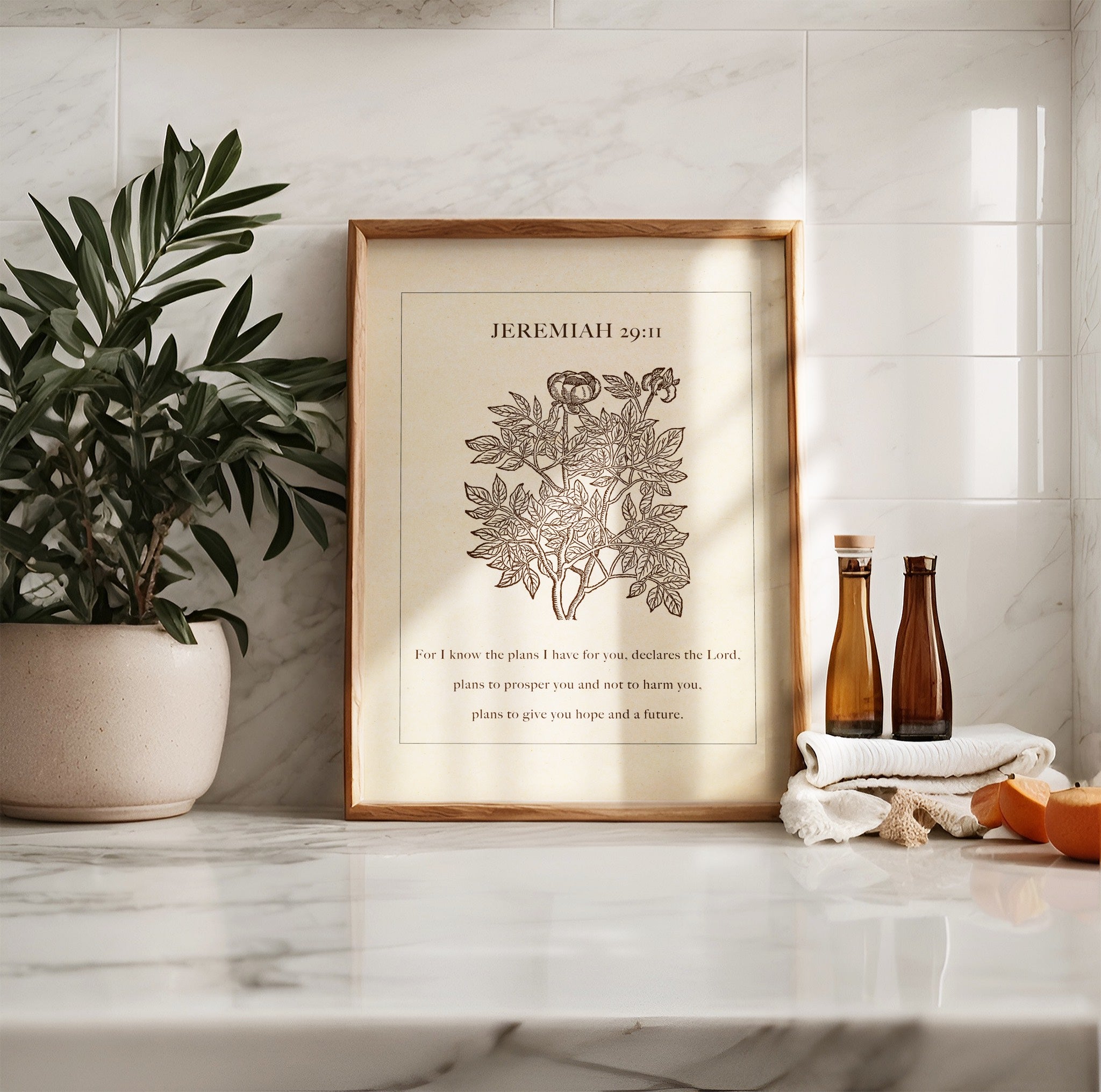 Jeremiah 29:11 botanical art print styled on a marble countertop, accompanied by a potted plant, amber bottles, and natural sunlight casting soft shadows.