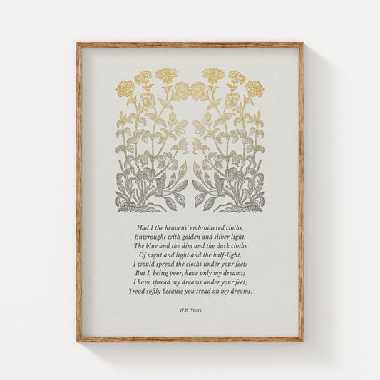 A vintage-style art print showcasing W.B. Yeats’ poem “He Wishes for the Cloths of Heaven,” adorned with elegant golden botanical illustrations, framed in natural wood against a neutral backdrop.