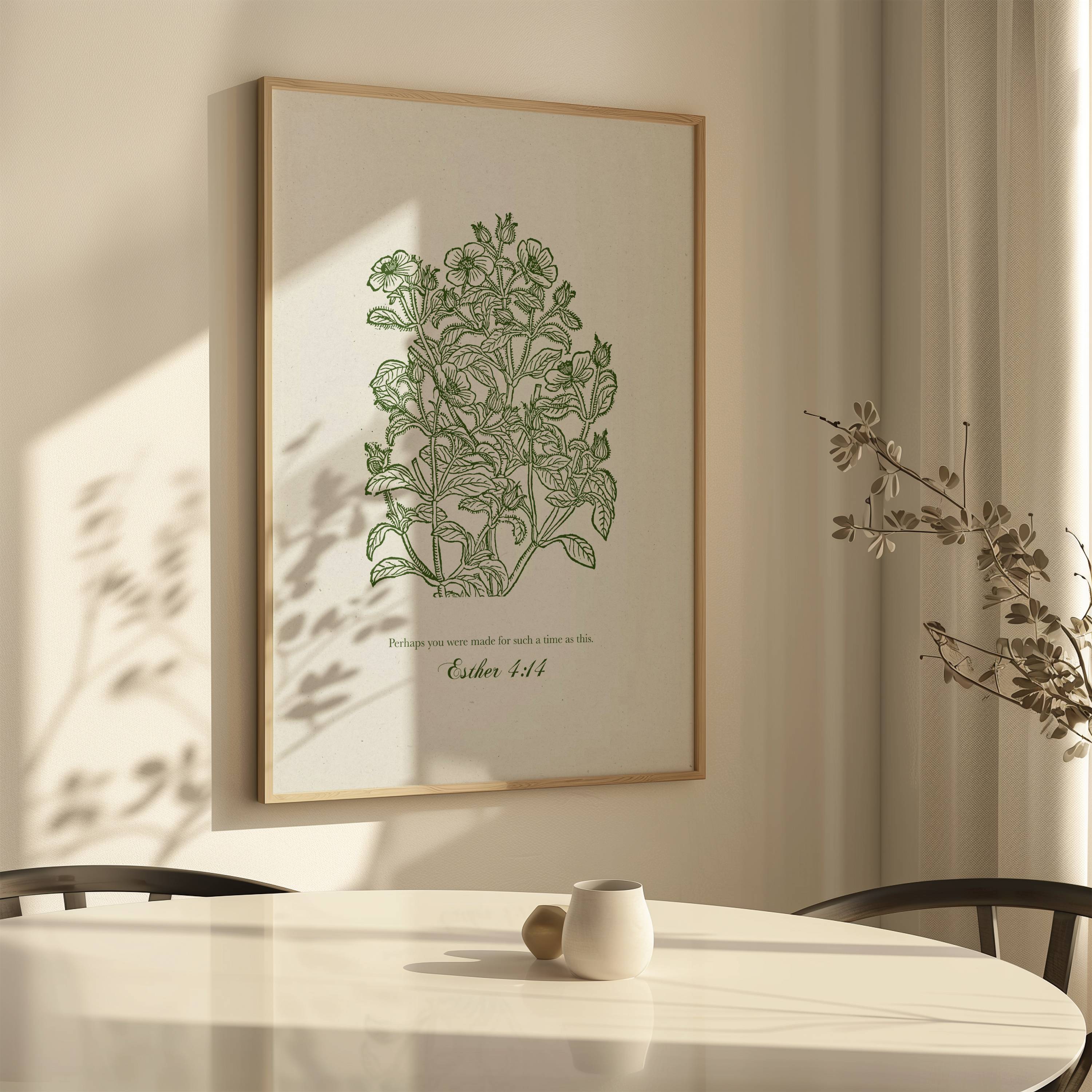 Framed Esther 4:14 Christian botanical art print on a wall above a table with a plant.