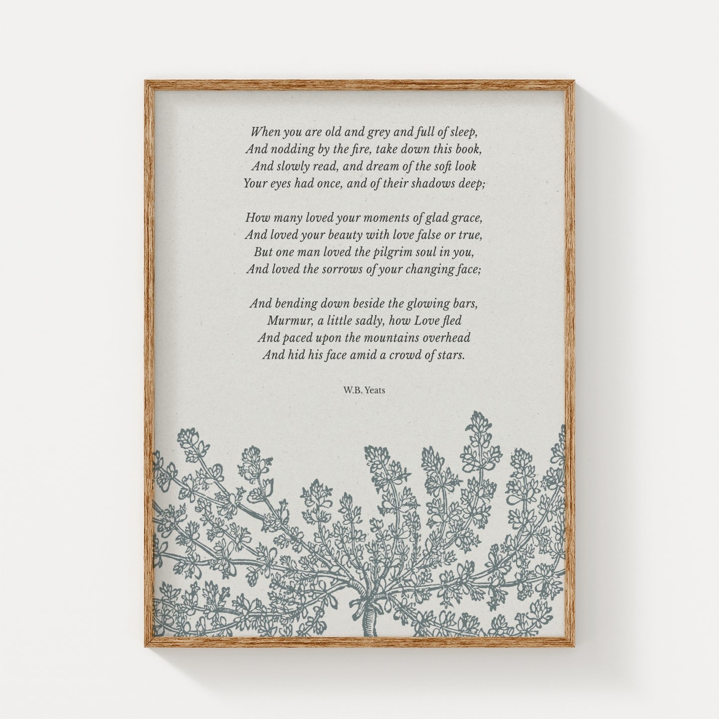 A vintage-inspired art print featuring W.B. Yeats’ poem “When You Are Old,” paired with an elegant floral illustration in soft gray tones, displayed in a natural wood frame on a neutral background.