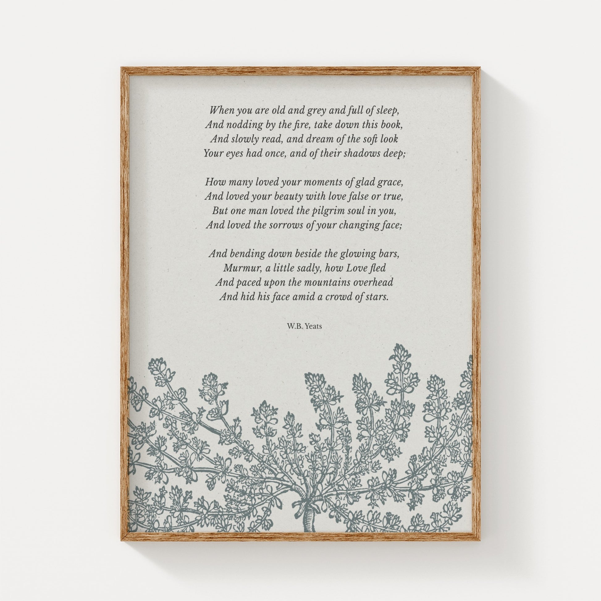 A vintage-inspired art print featuring W.B. Yeats’ poem “When You Are Old,” paired with an elegant floral illustration in soft gray tones, displayed in a natural wood frame on a neutral background.