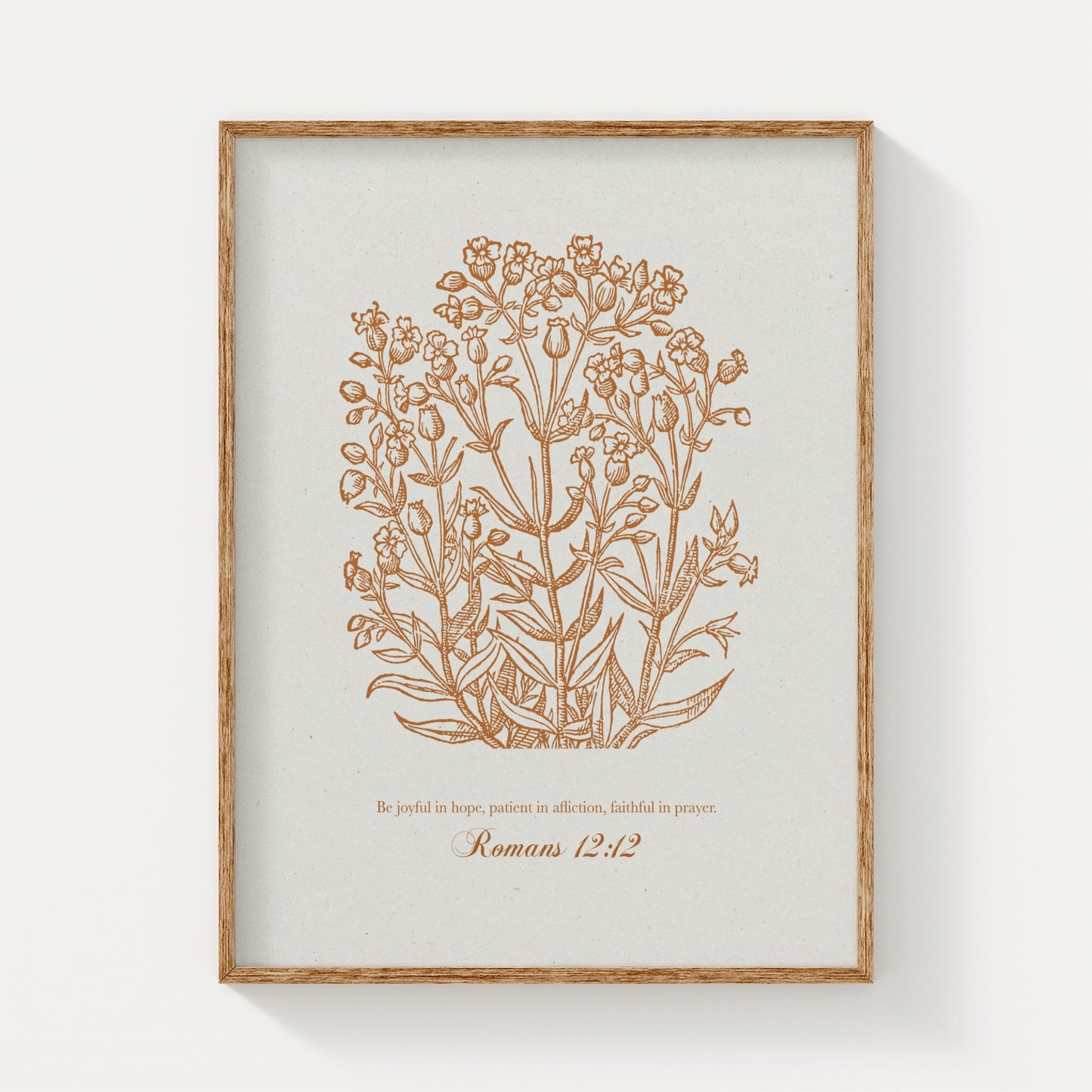 Warm golden botanical print with Romans 12:12, displayed in a natural wood frame on a light beige background for a timeless, vintage aesthetic.