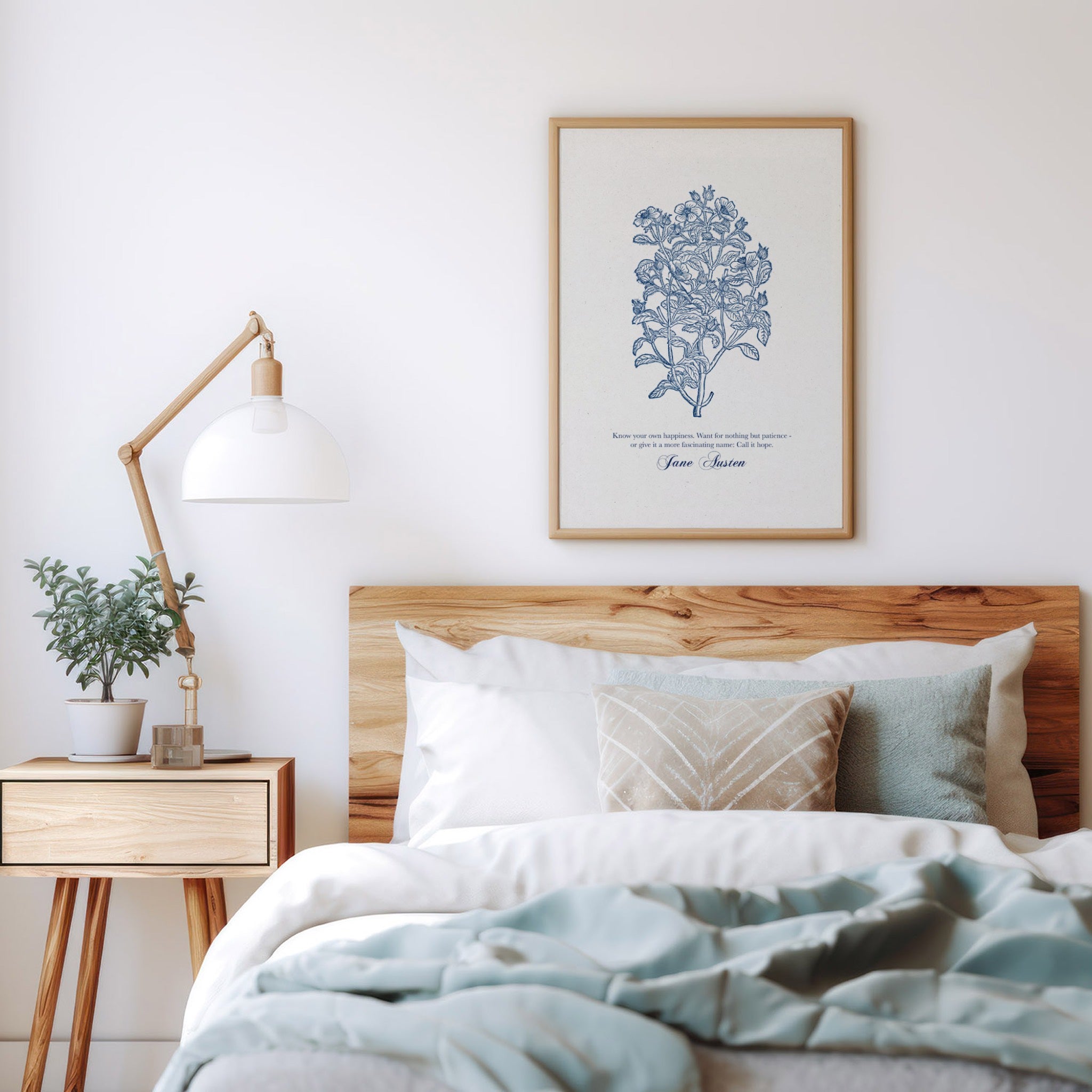 Botanical art print featuring delicate blue floral illustrations and the quote “Know your own happiness” by Jane Austen, framed in natural wood and styled above a cozy bed with neutral bedding and soft decor.
