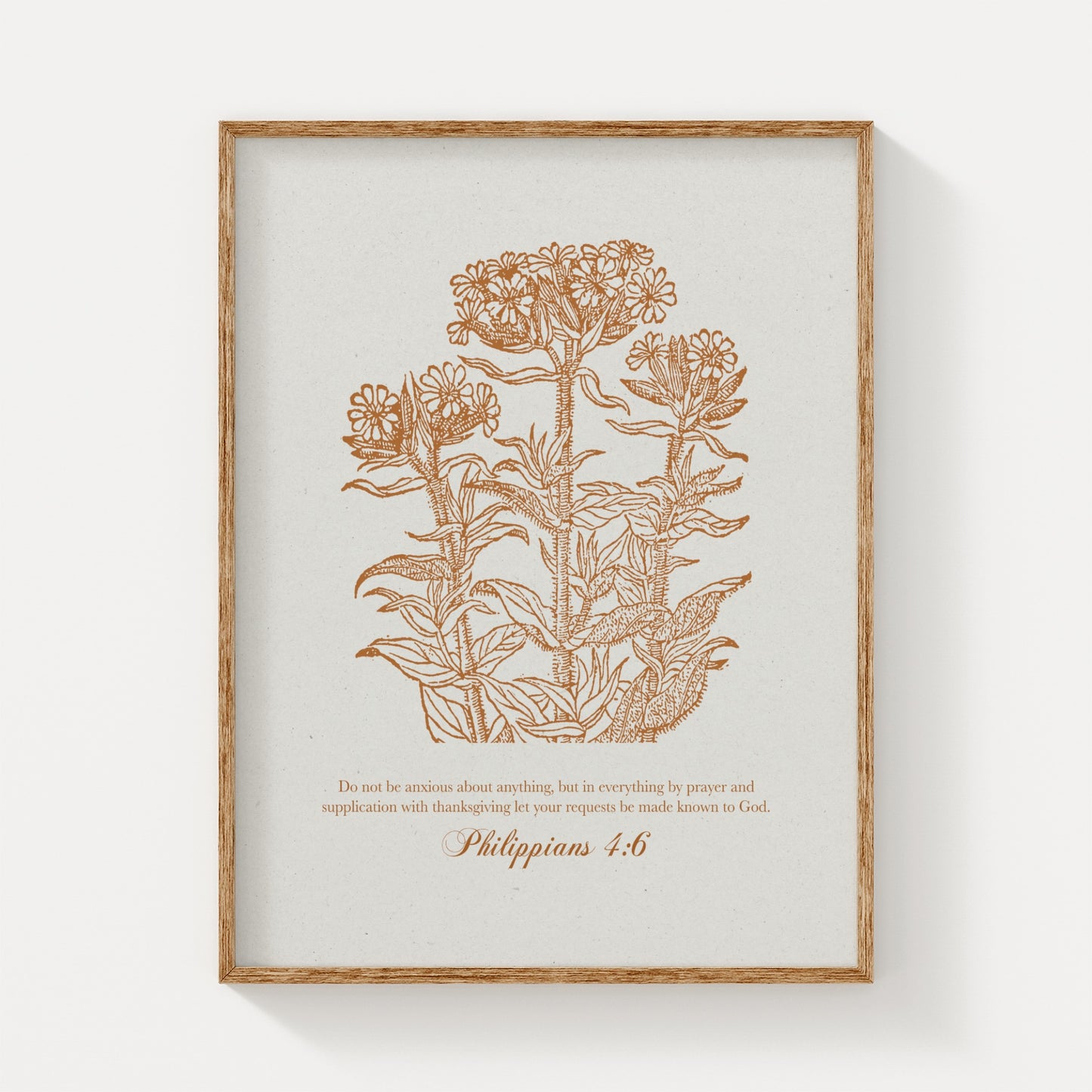 Golden brown vintage floral botanical print featuring Philippians 4:6, displayed in a natural wood frame on a clean, white background for a minimalist look.