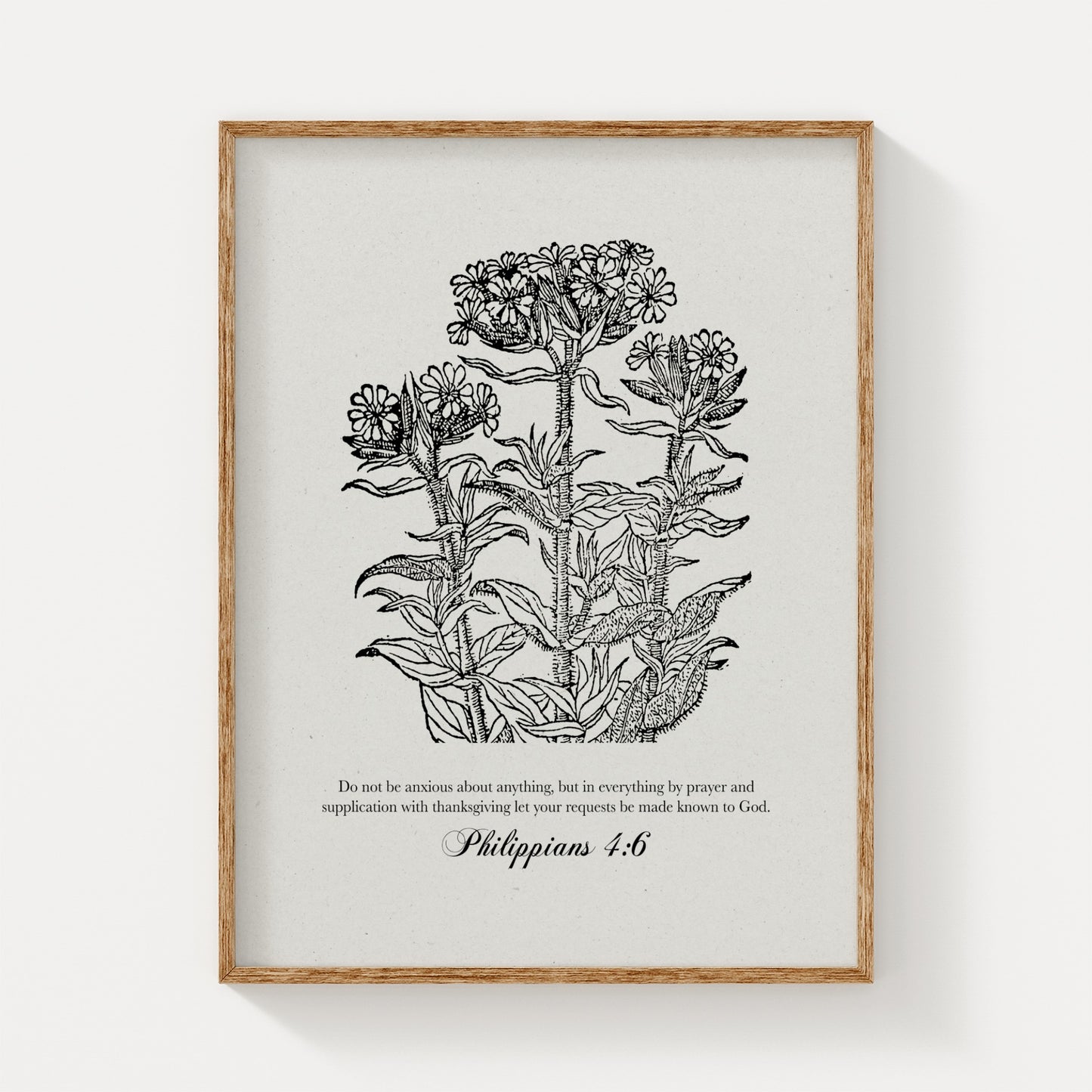Black vintage floral botanical print featuring Philippians 4:6, displayed in a natural wood frame on a clean, white background for a minimalist look.