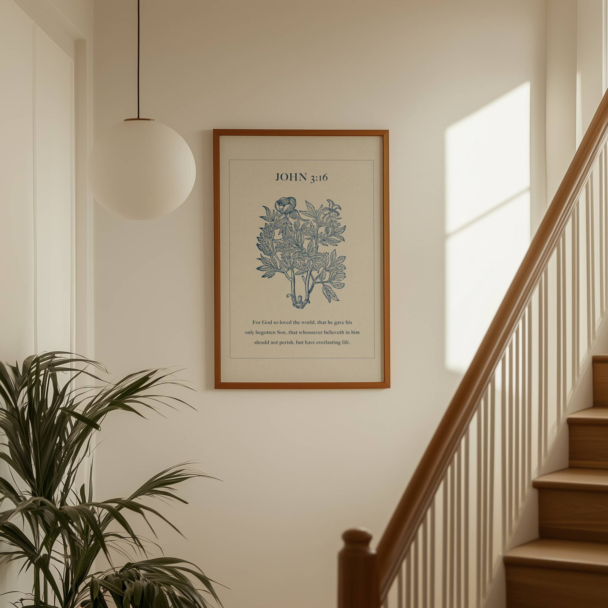 Framed artwork featuring John 3:16 Scripture and blue botanical on a wall above a staircase