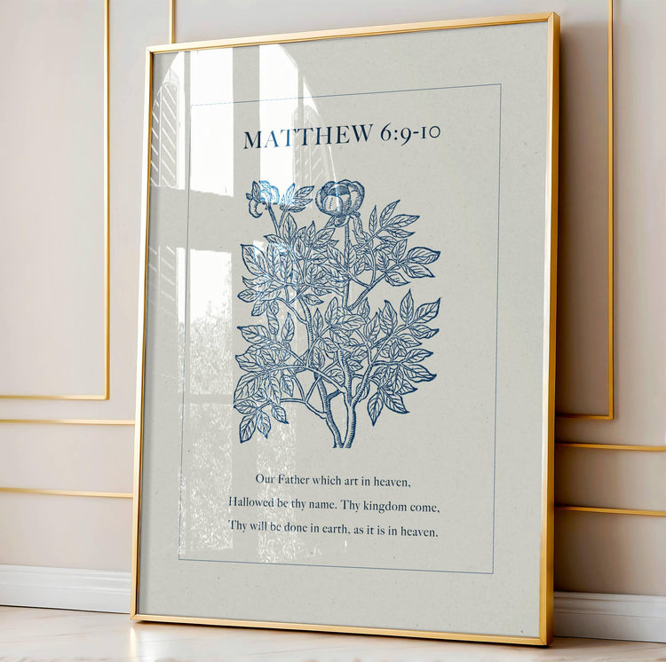 Framed artwork with floral design and Bible verse from Matthew 6:9-10 on a light background